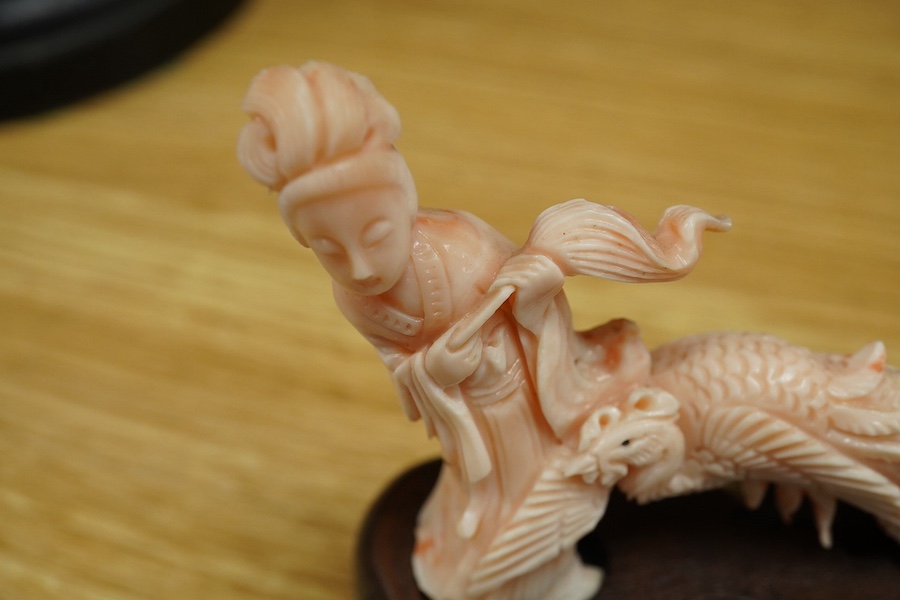 A Chinese coral group of a lady and a phoenix on carved hardwood base, 11cm high. Condition - good